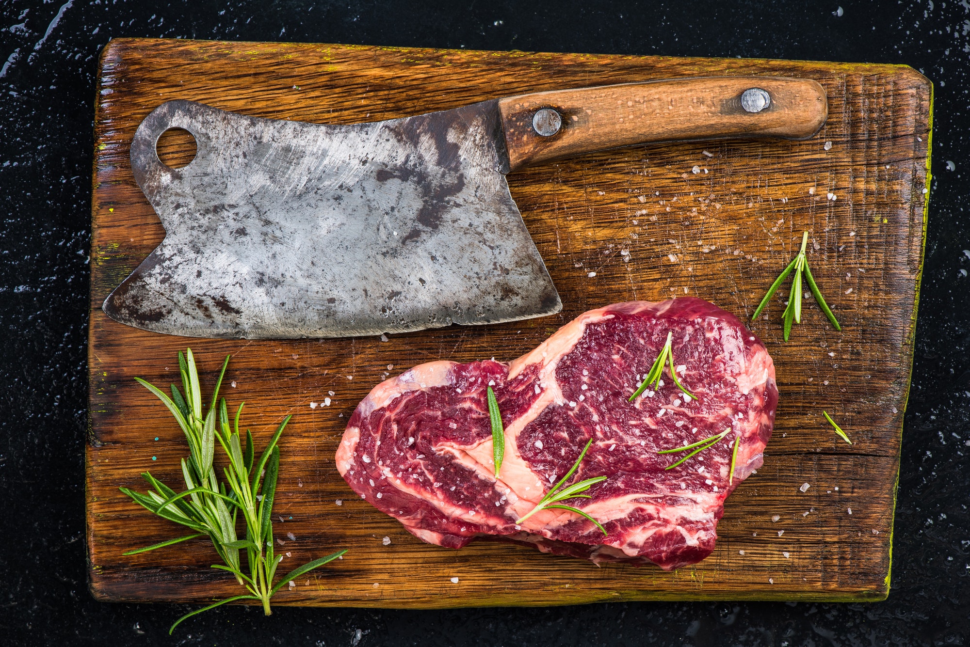 Butcher axe and piece of beef meat steak