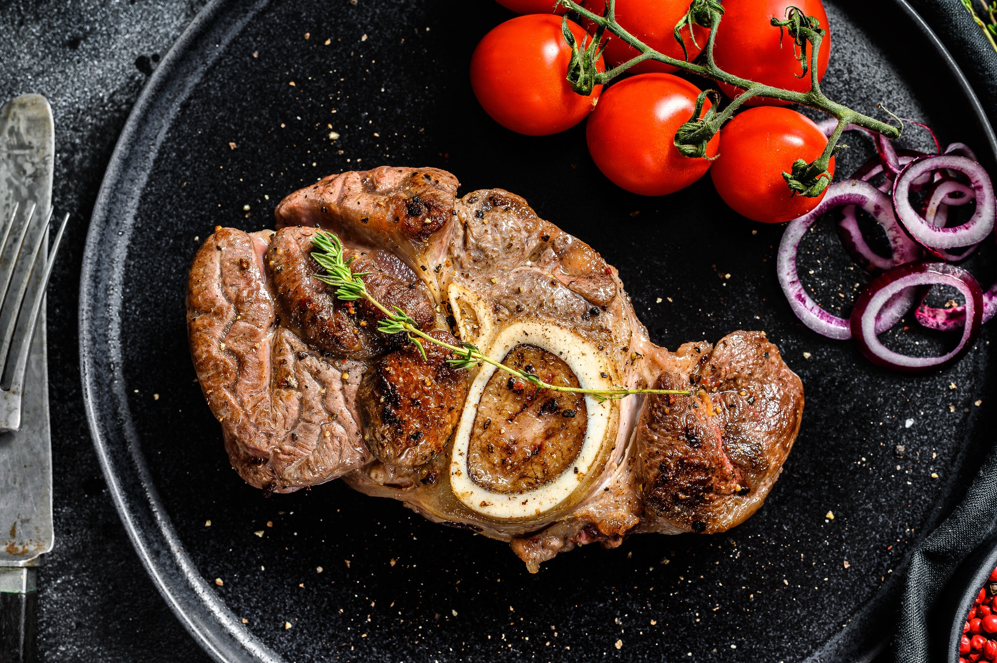 Osso buco, cooked Veal shank. Ossobuco meat. Black background. Top view