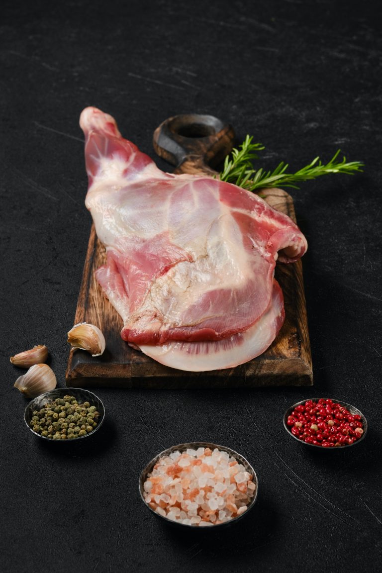 Raw lamb shoulder on wooden cutting board