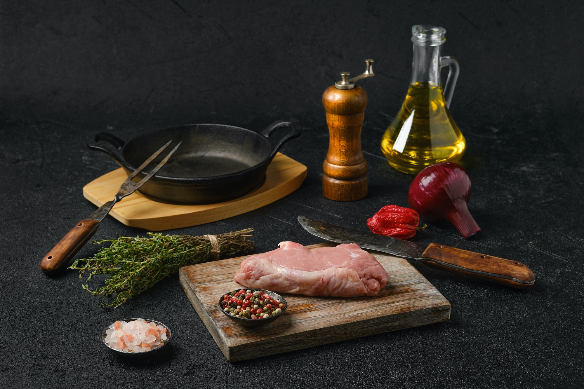 Raw veal steak bone in with ingredients for cooking